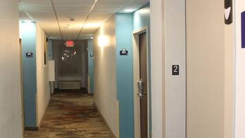 A hotel hallway with carpeted floors, white walls, and doors numbered 2, 3, and 4.