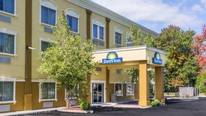 Un hôtel Days Inn avec une façade jaune, de nombreuses fenêtres et une enseigne de station-service.