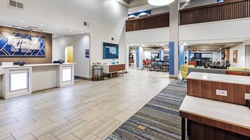 A spacious lobby with a reception desk, seating area, and a dining section.