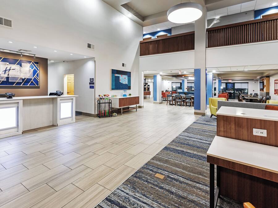 A spacious lobby with a reception desk, seating area, and a dining section.