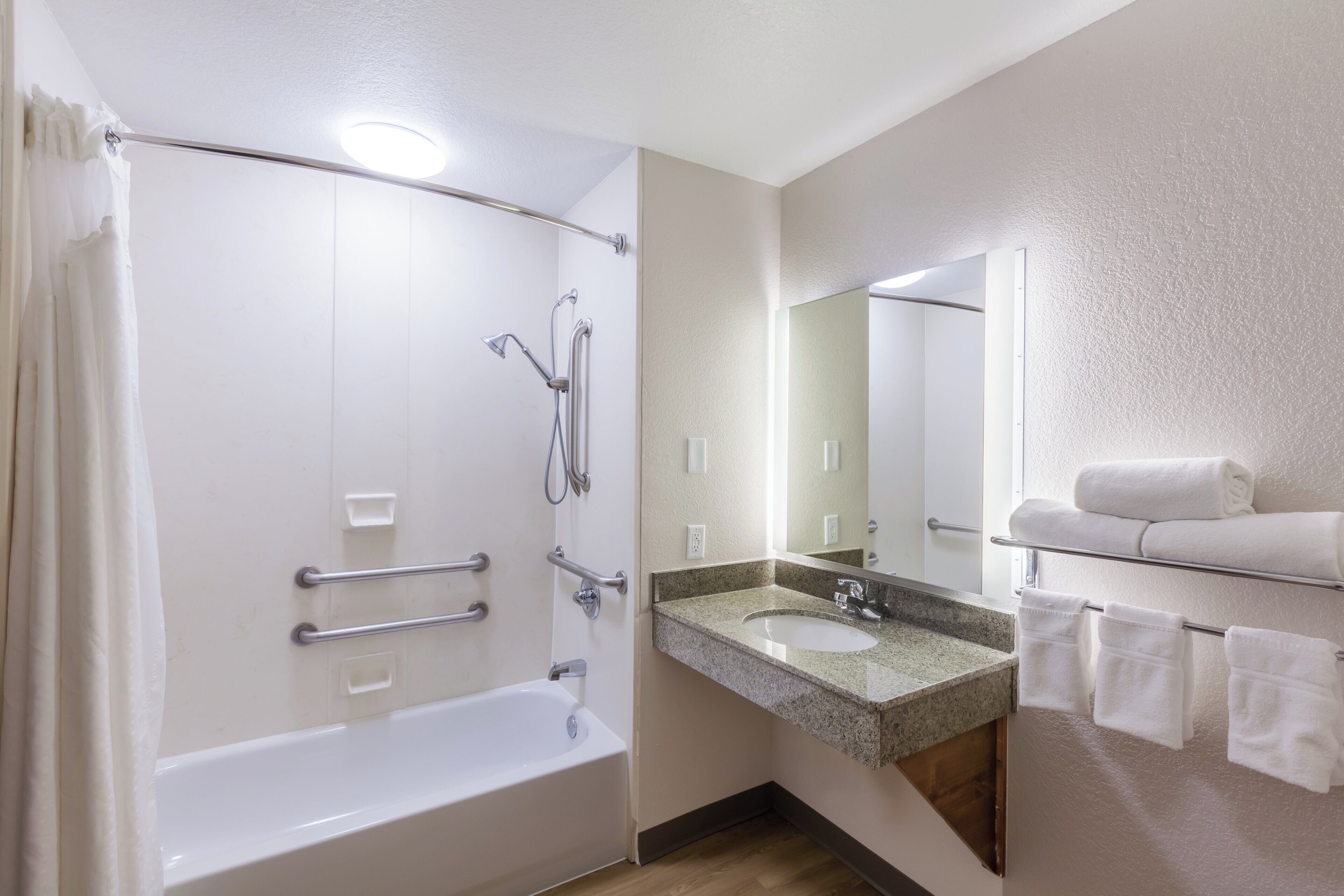 Un baño con bañera, ducha, lavabo y espejo.