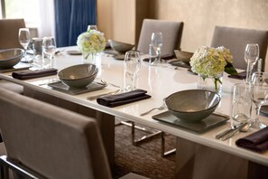 A dining table set with bowls, glasses, and a vase of flowers. - Hilton Baltimore BWI Airport (Linthicum Heights)