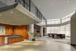 A spacious lobby with a reception desk, seating area, and large windows allowing natural light. - Hilton Baltimore BWI Airport (Linthicum Heights)