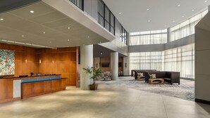 A spacious lobby with a reception desk, seating area, and large windows allowing natural light. - Hilton Baltimore BWI Airport (Linthicum Heights)