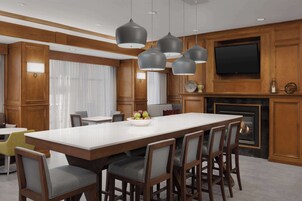 Una cocina moderna con una isla grande, armarios de madera y un televisor de pantalla plana montado sobre la chimenea.