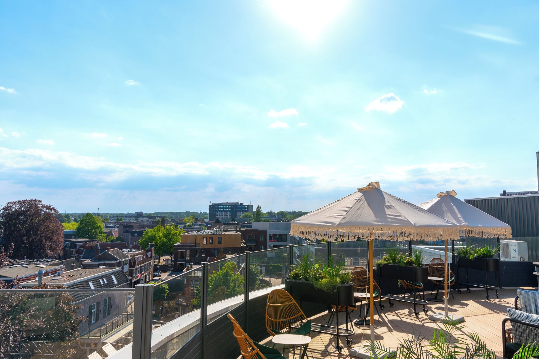 A rooftop terrace with outdoor seating and a large umbrella.