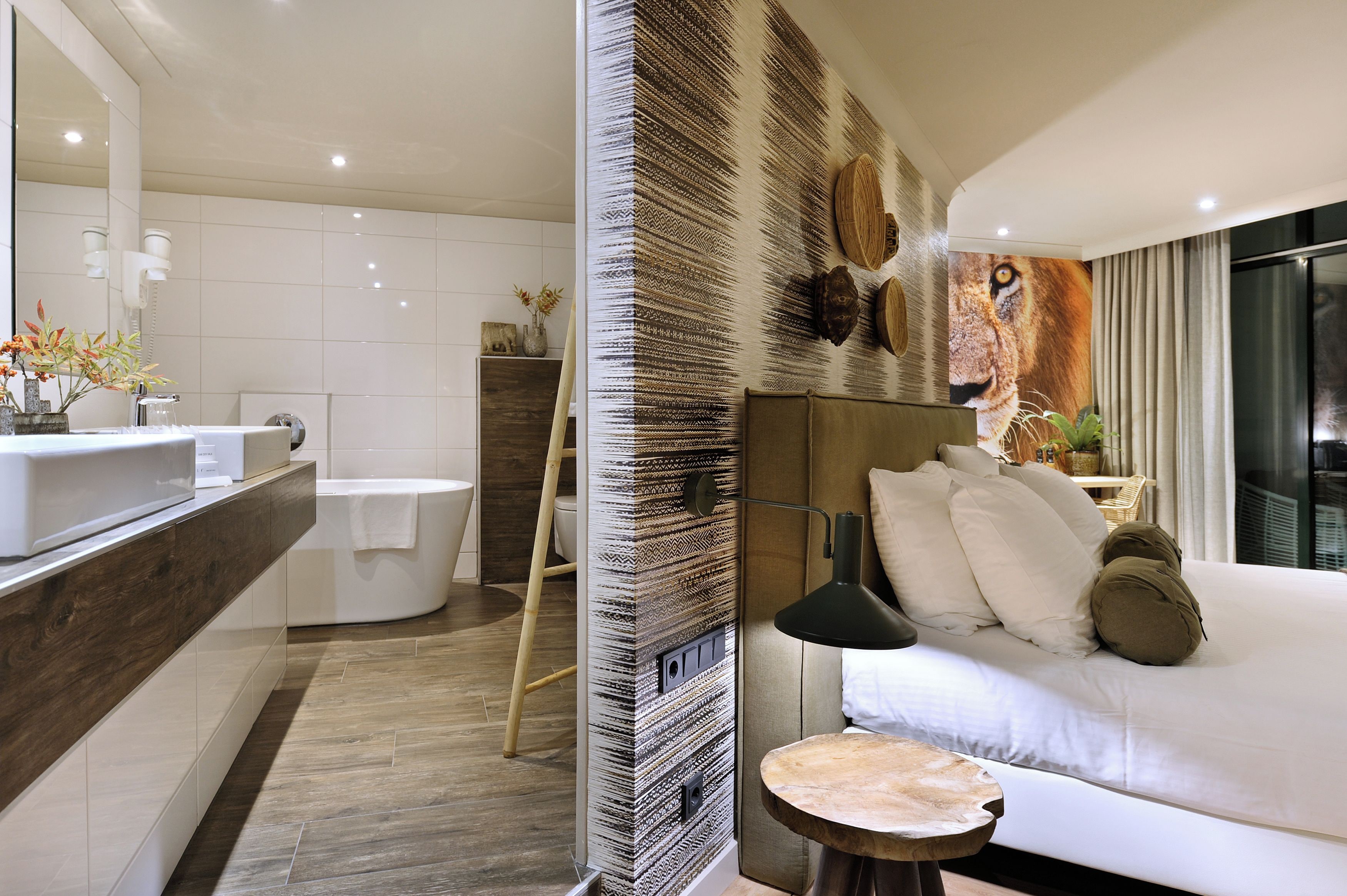 A modern bathroom with a bathtub, a large mirror, and a shower area.