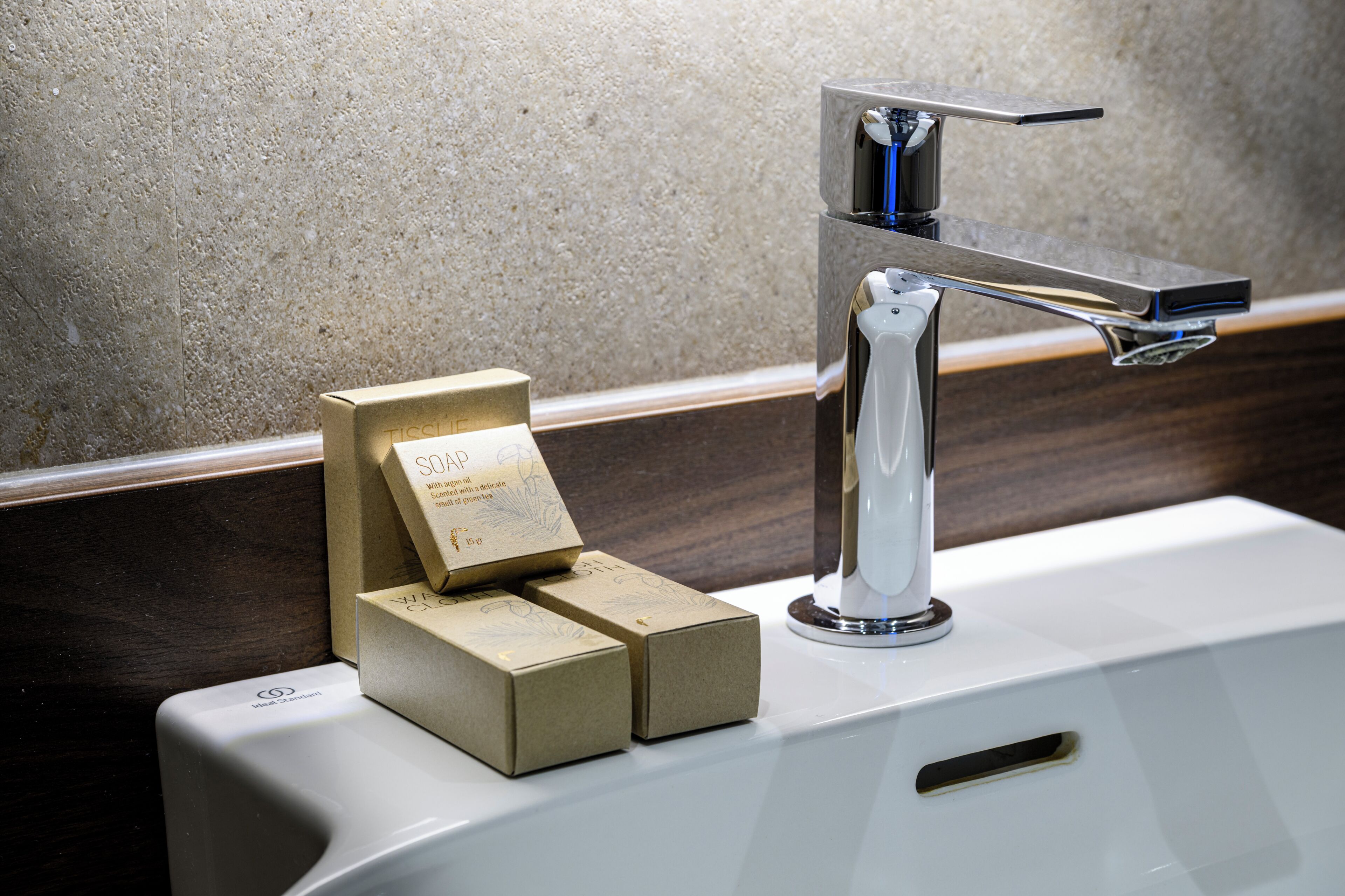A bathroom sink with a modern faucet and a soap dispenser.