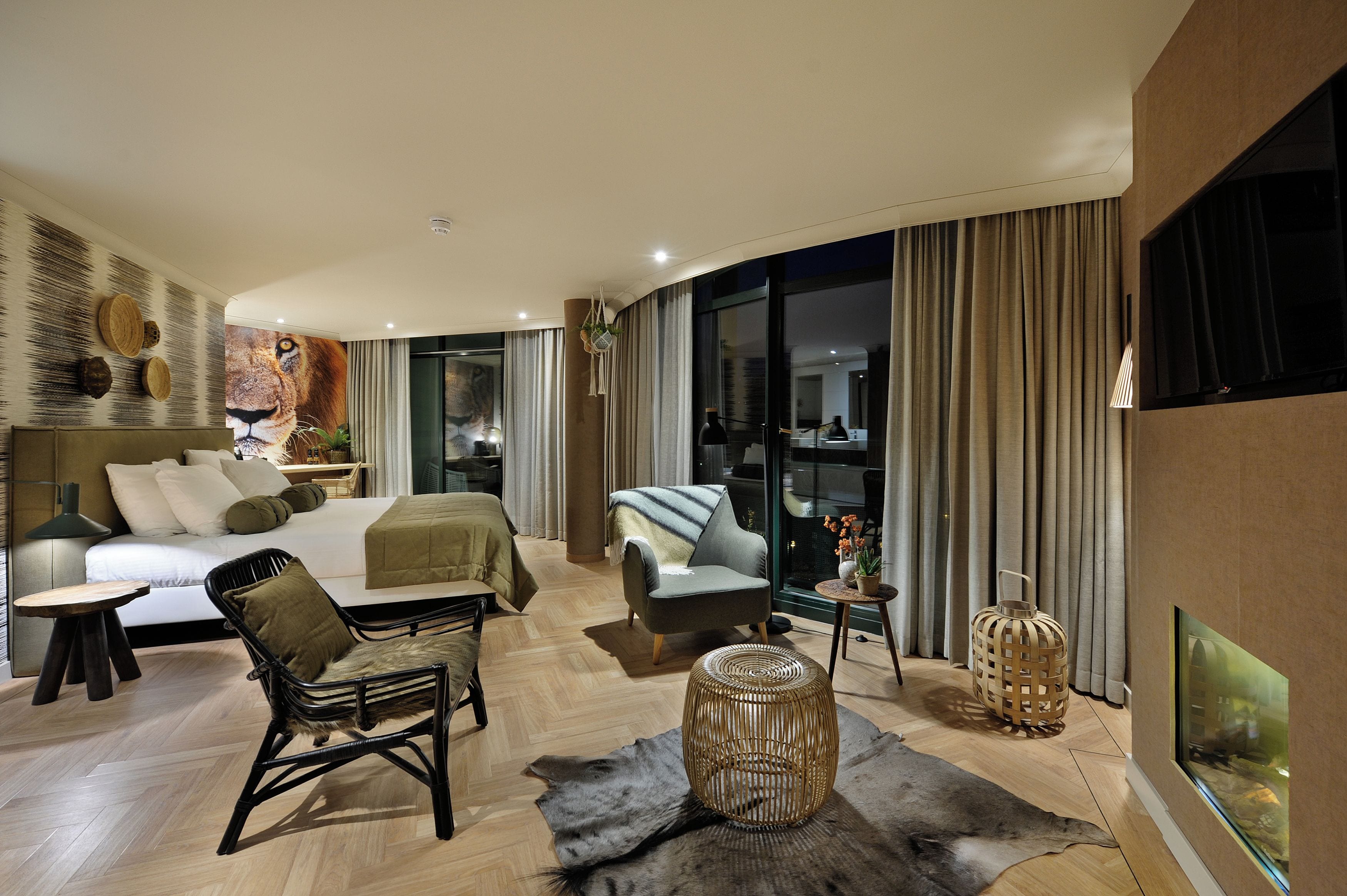 Una habitación de hotel moderna con cama, zona de estar y vistas a la ciudad.