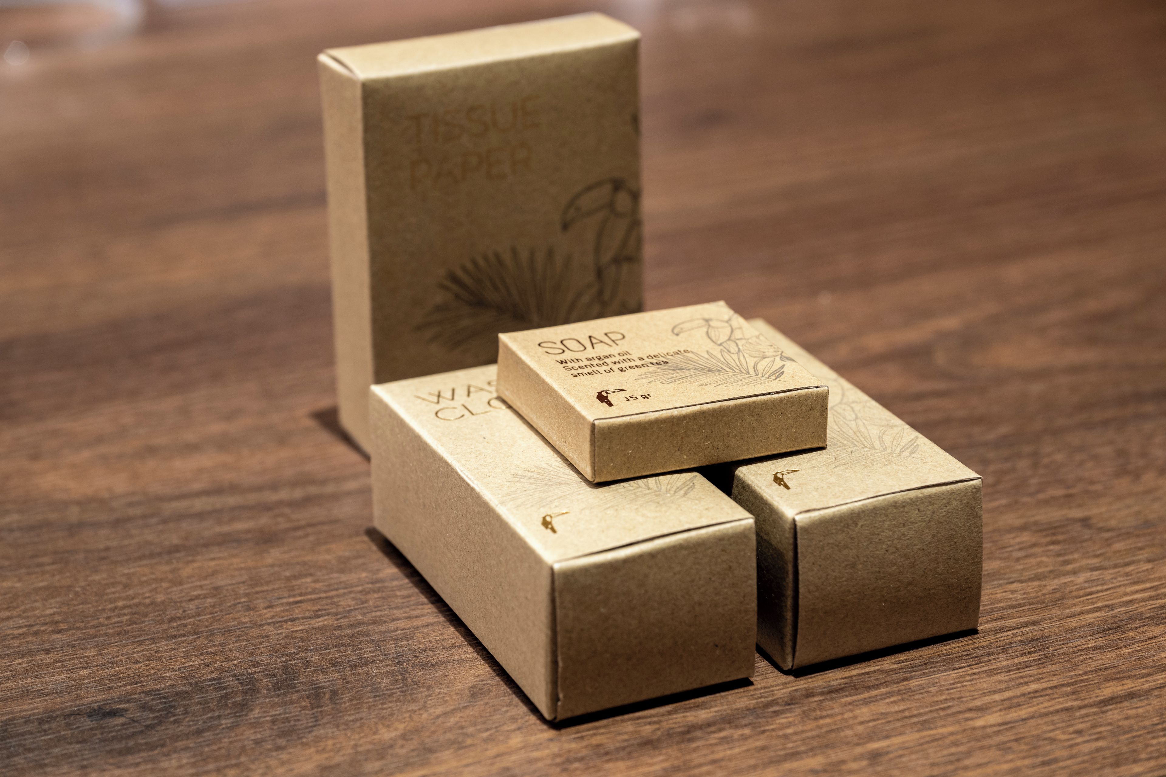 Three cardboard boxes with text on them, placed on a wooden surface.