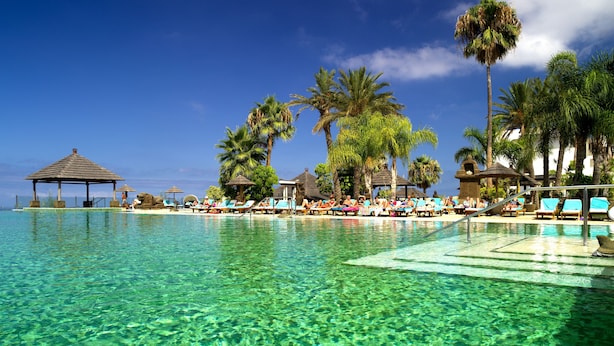A clear pool with lounge chairs and palm trees. - Regency Country Club, Apartments Suites (Arona)