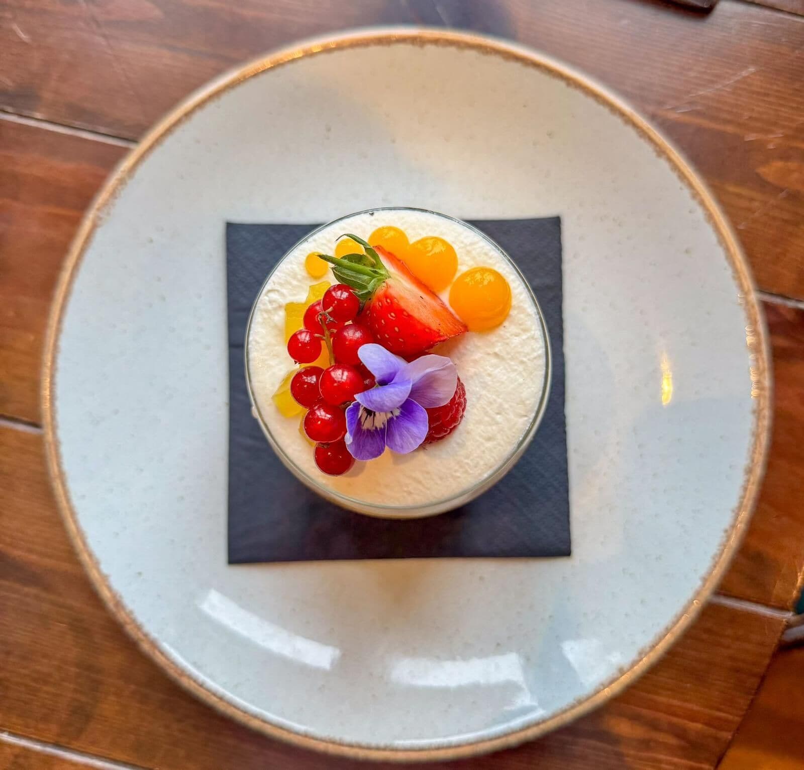 A dessert on a plate with a square napkin underneath.