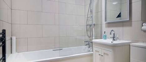A modern bathroom with a bathtub, a shower, and a sink.