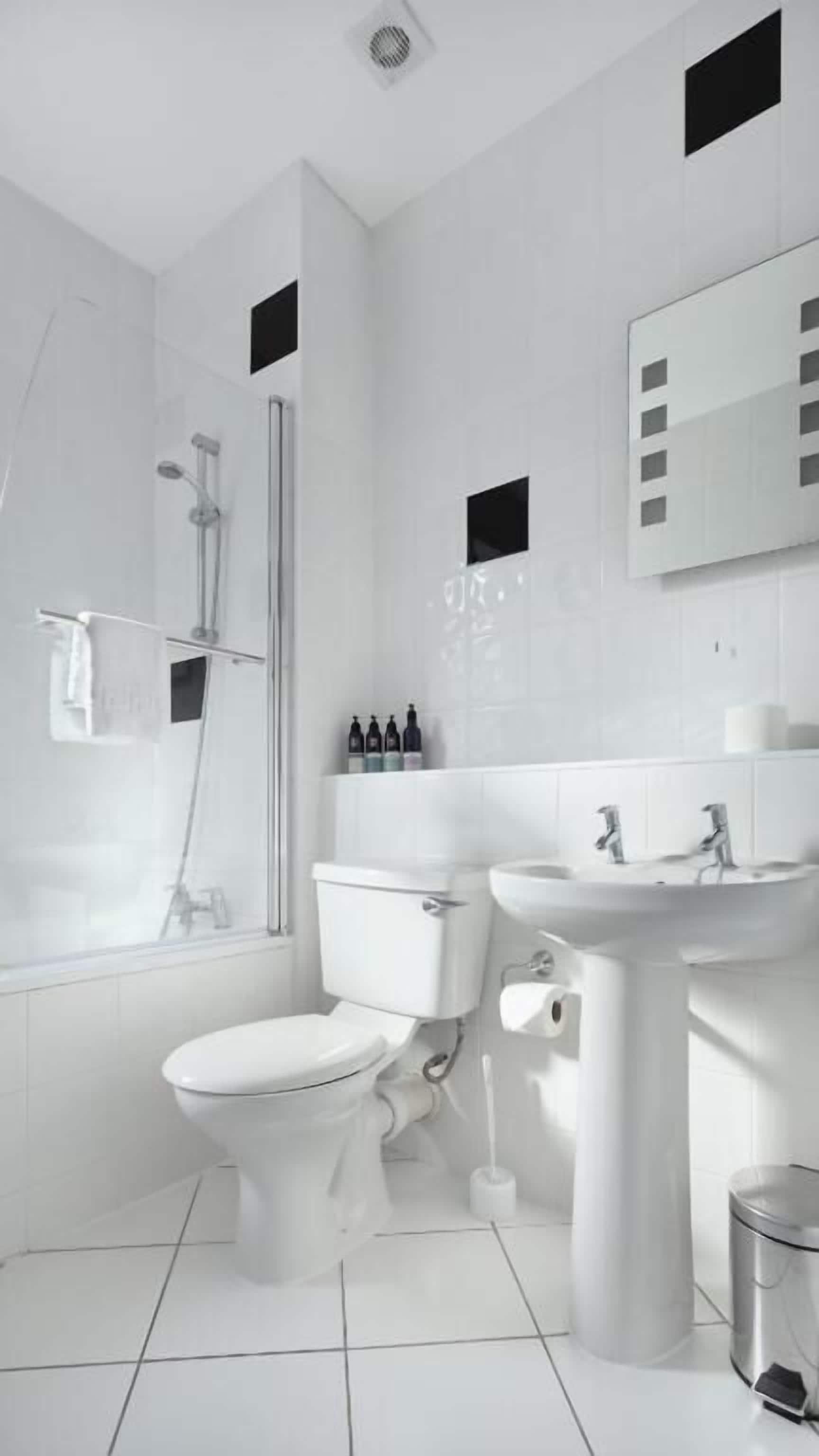 Et moderne badeværelse med toilet, bidet og håndvask.