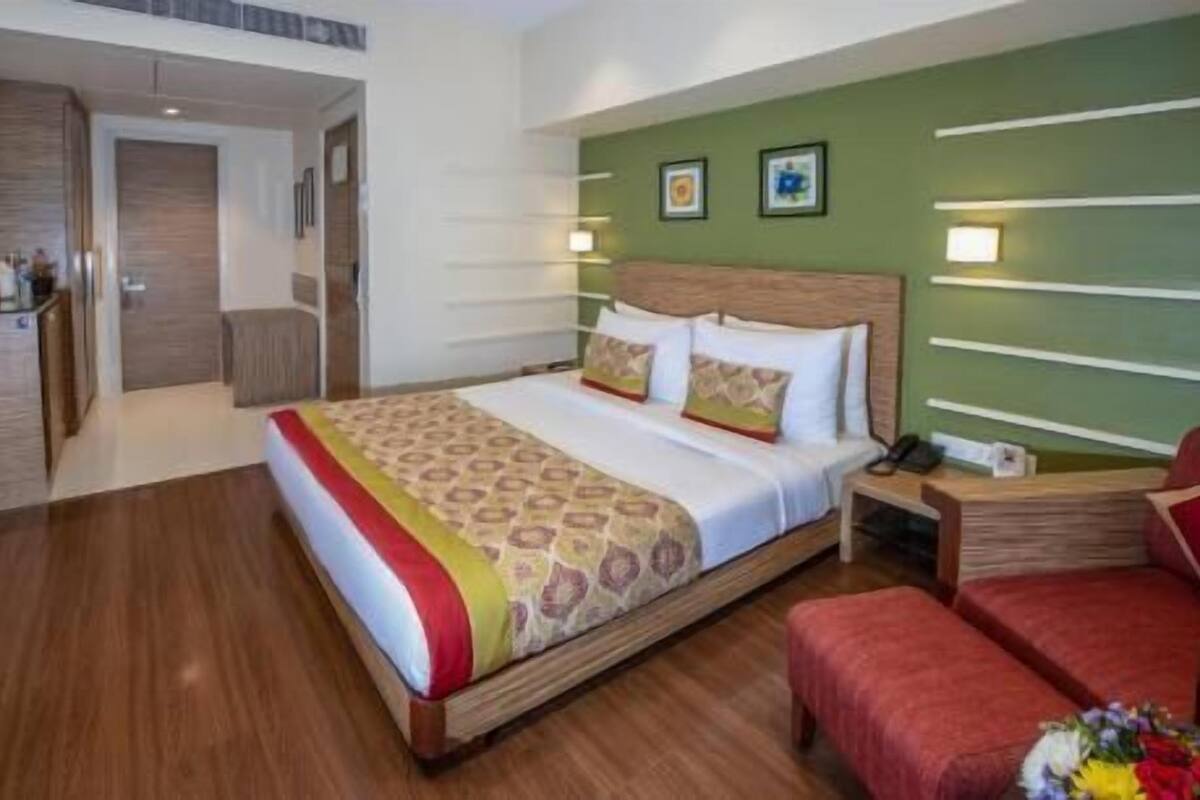 Ein Hotelzimmer mit Bett, Nachttisch und einer kleinen Sitzecke.