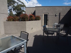 Enjoy dining or socializing in this outdoor space with a glass-top table and four chairs.