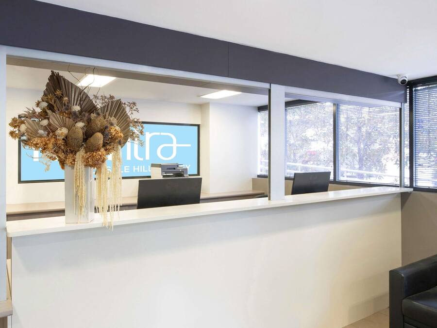 A reception desk with a large screen displaying 'THE HILL' and 'HILL'S HILL'.