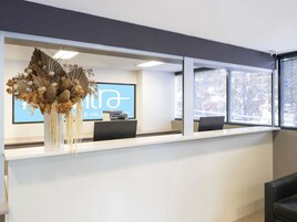 Una mesa de recepción con una pantalla grande que muestra 'THE HILL' y 'HILL'S HILL'.
