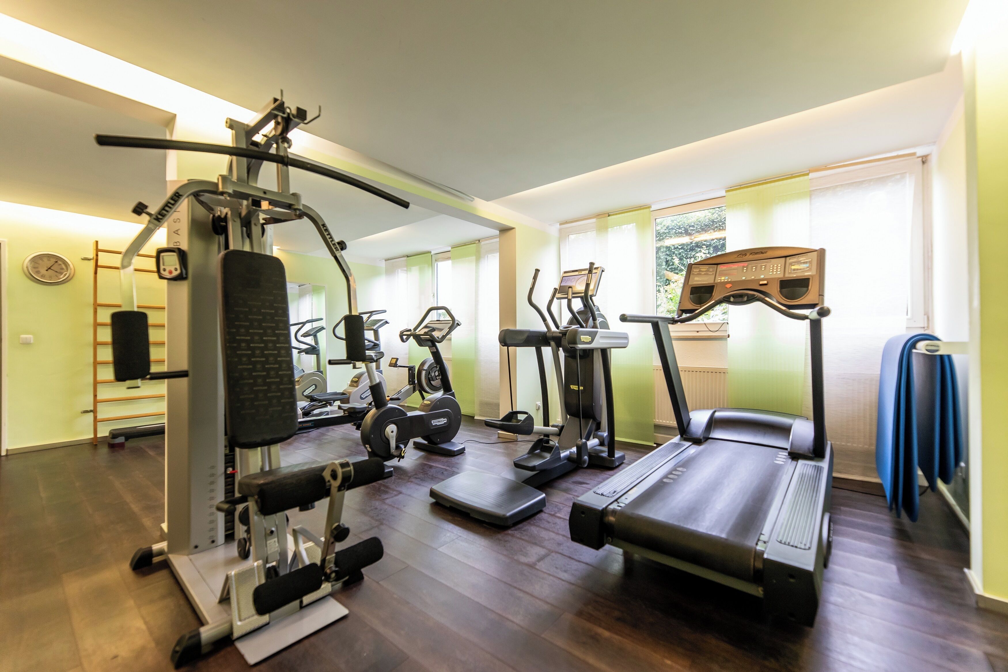 Ein Heimfitnessraum mit Laufband, Crosstrainer und Kraftgerät.
