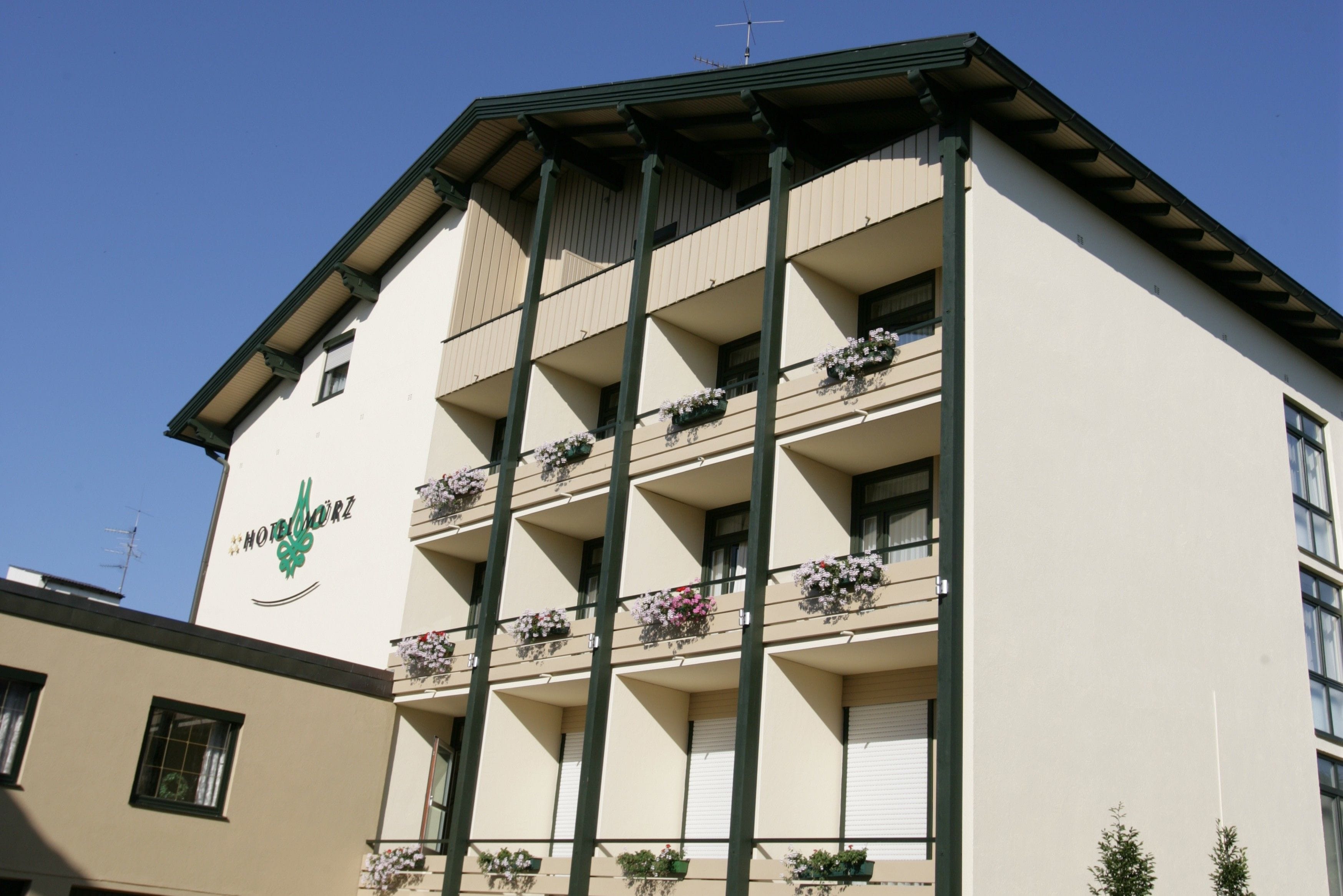 A multi-story hotel with balconies, each with flower boxes.