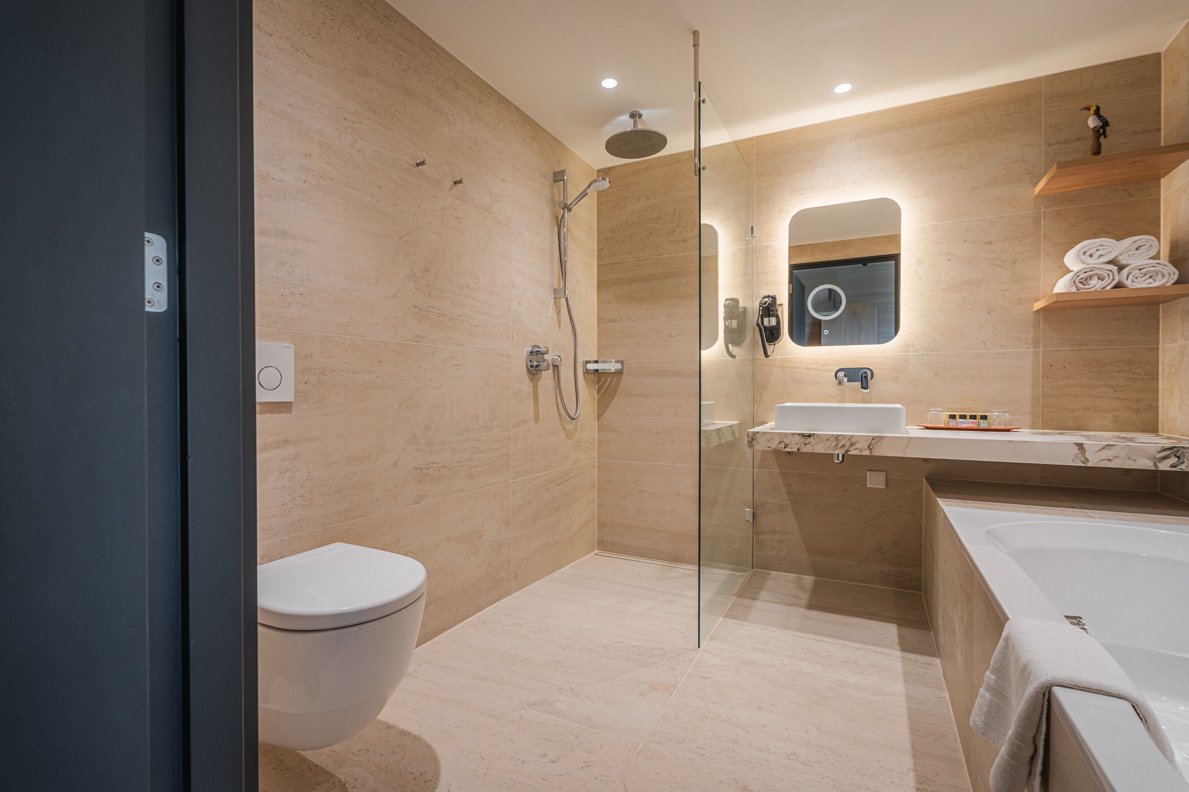 A modern bathroom with a glass-enclosed shower, a toilet, a sink, and a bathtub.