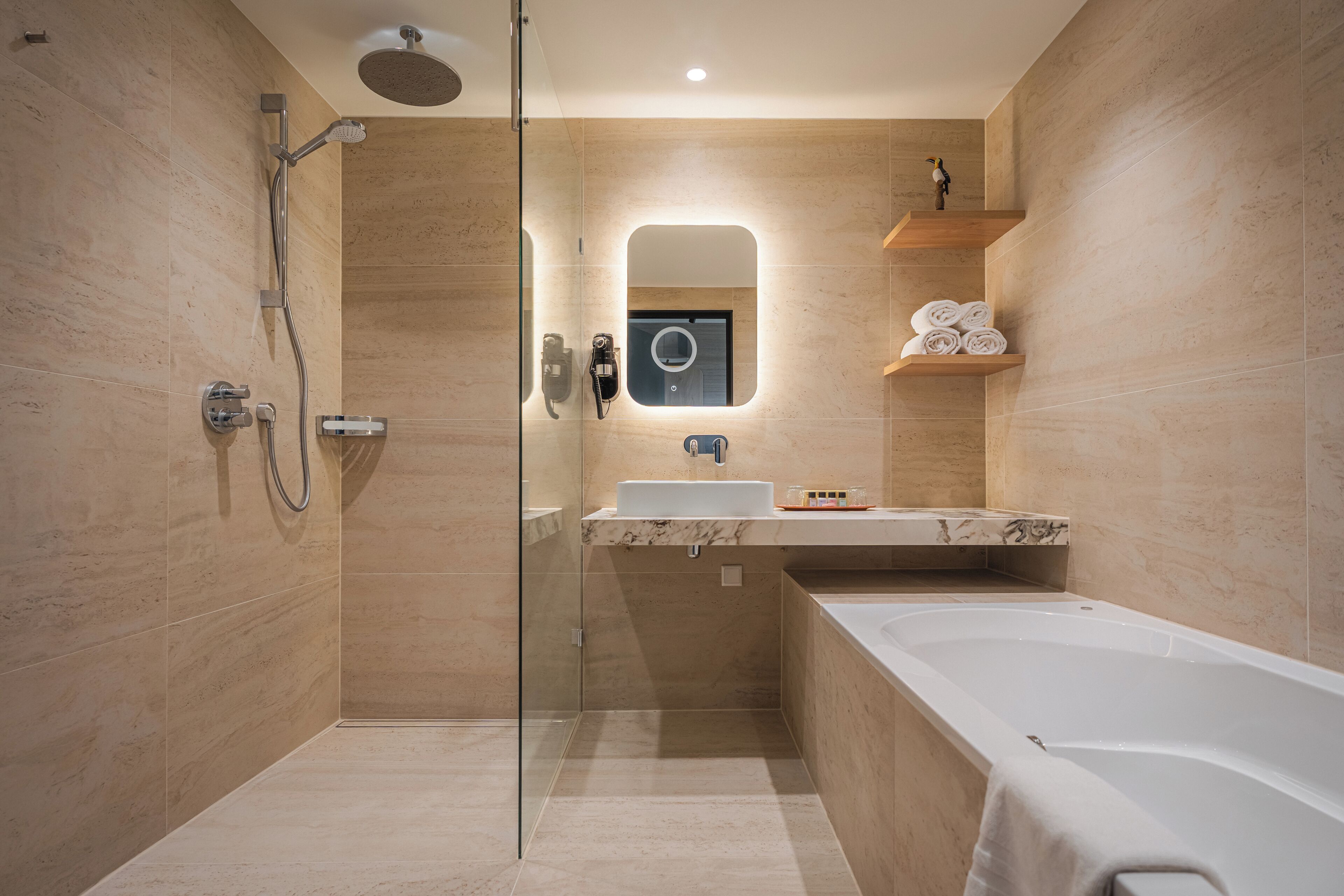 A modern bathroom with a glass-enclosed shower, a marble sink, and a bathtub.