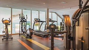 Een sportschool met loopbanden, elliptische trainers en gewichttoestellen.
