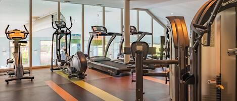 A gym with treadmills, elliptical machines, and weight equipment.