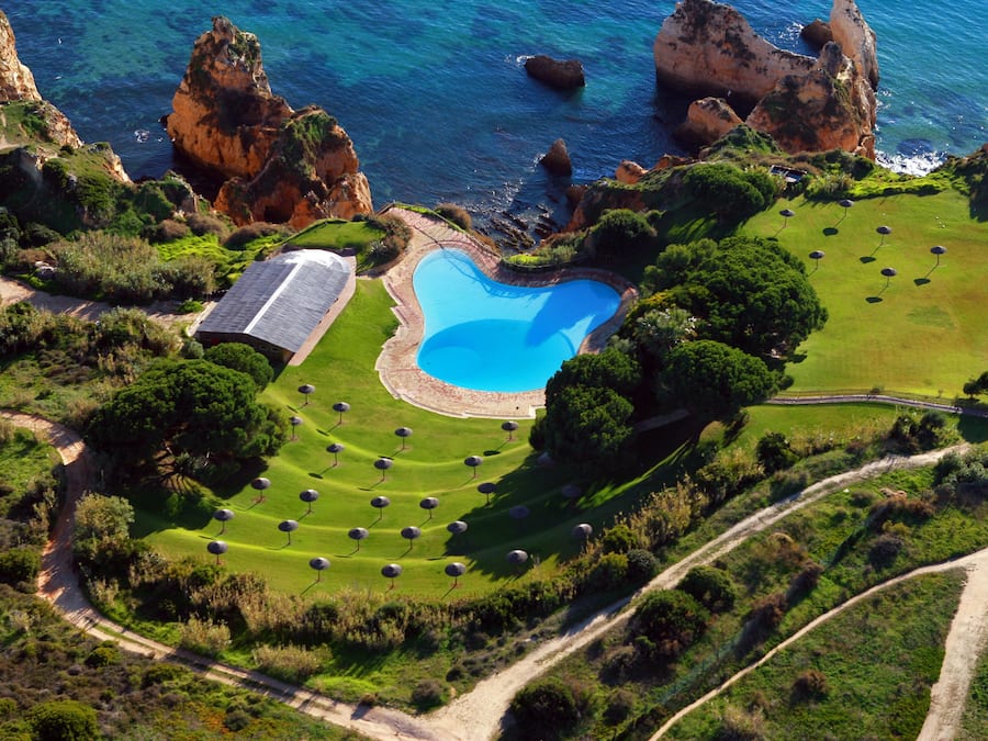 Una piscina al aire libre de temporada, sombrillas