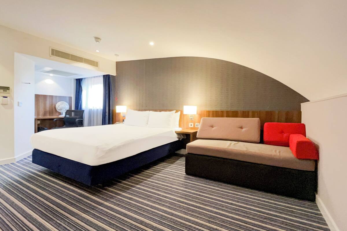 Een hotelkamer met een groot bed, een bank en een bureau.