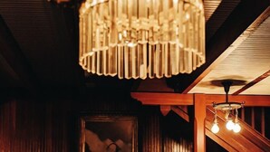 Una habitación acogedora con chimenea, un cuadro en la pared y una lámpara colgante.