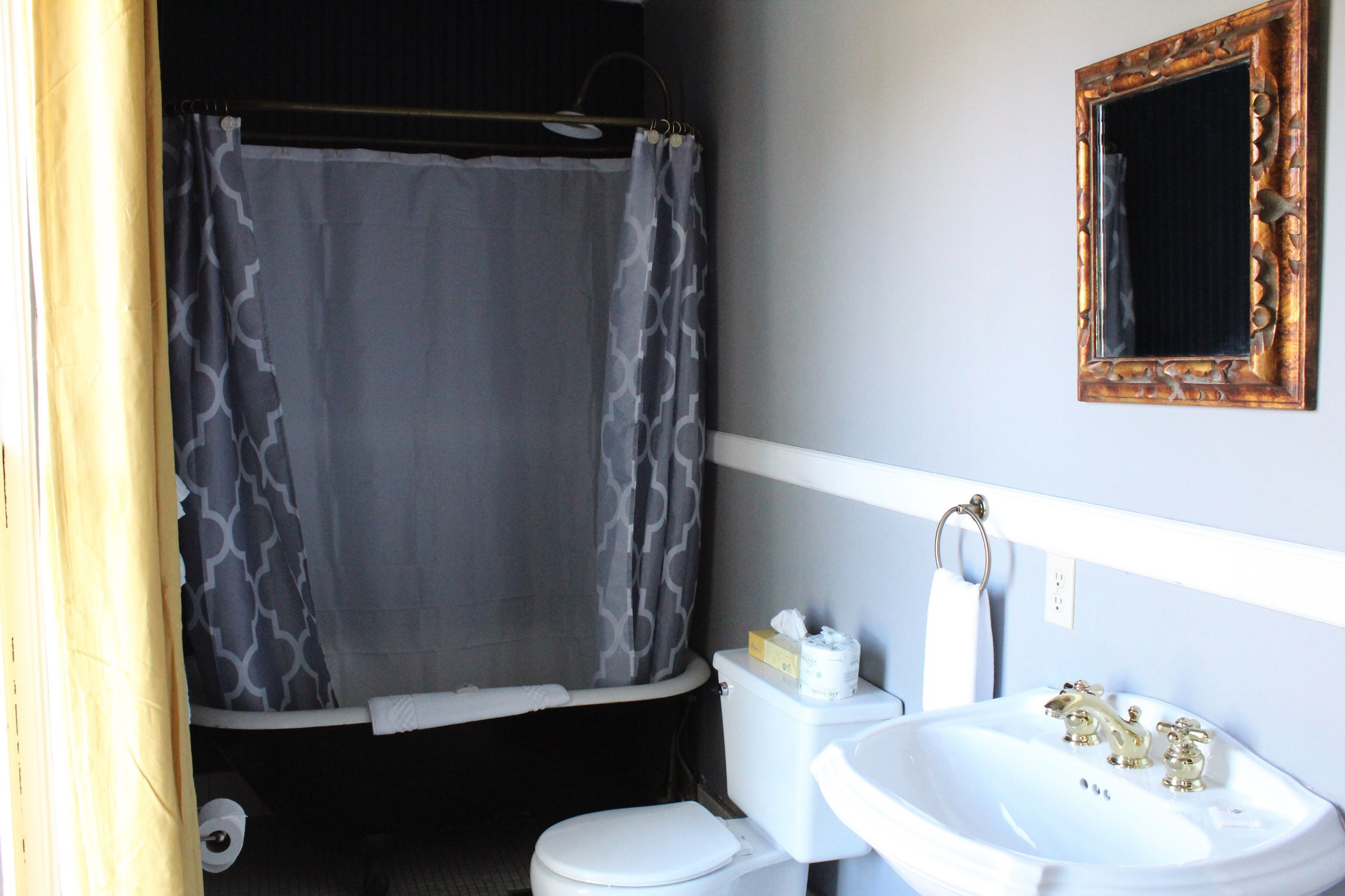 A bathroom with a toilet, sink, and shower curtain.