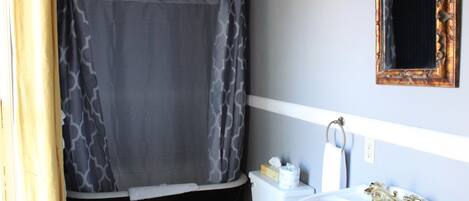 A bathroom with a toilet, sink, and shower curtain.