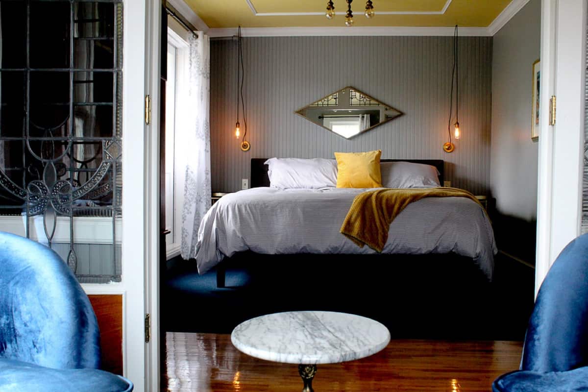 A bedroom with a bed, a round table, and two chairs.