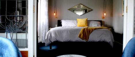 A bedroom with a bed, a round table, and two chairs.