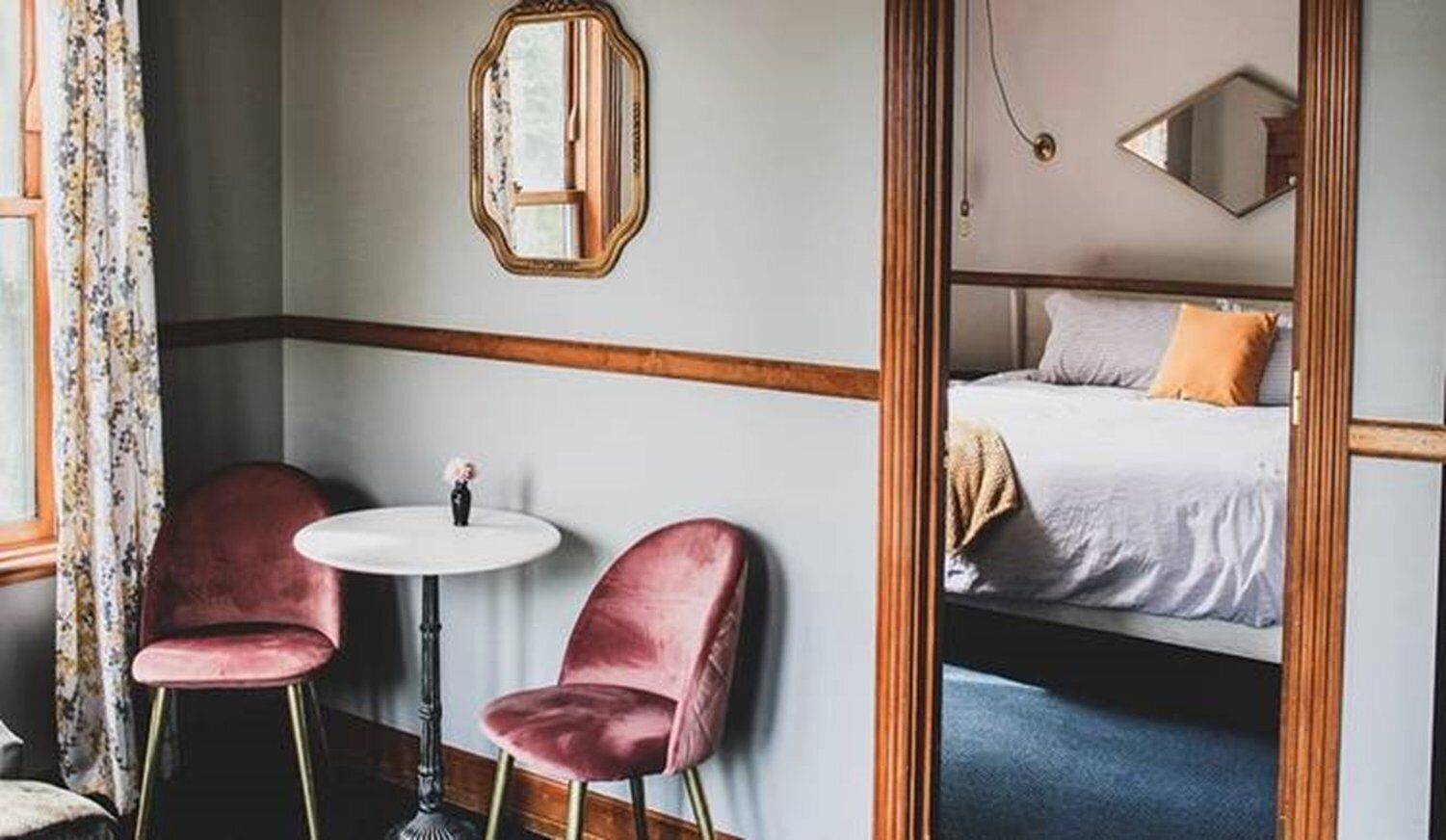 Ein Zimmer mit einem Bett, einem runden Tisch und zwei Stühlen.