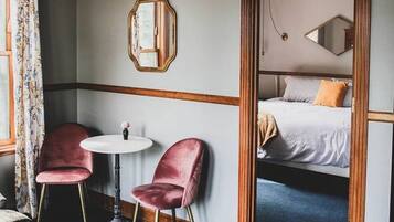 Ein Zimmer mit einem Bett, einem runden Tisch und zwei Stühlen.