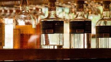 Un bar con varias botellas de licores en estanterías.