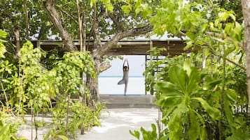 Un espacio al aire libre cubierto con una terraza de madera y vista al mar.