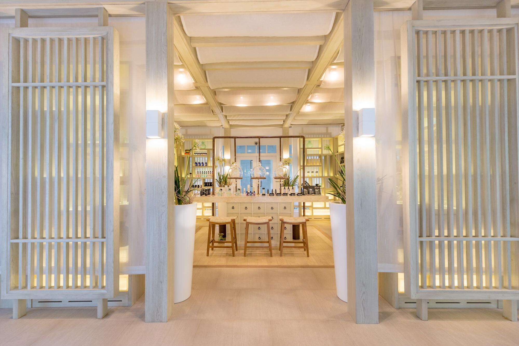 A bar area with a central counter, stools, and a mirrored wall reflecting the interior.