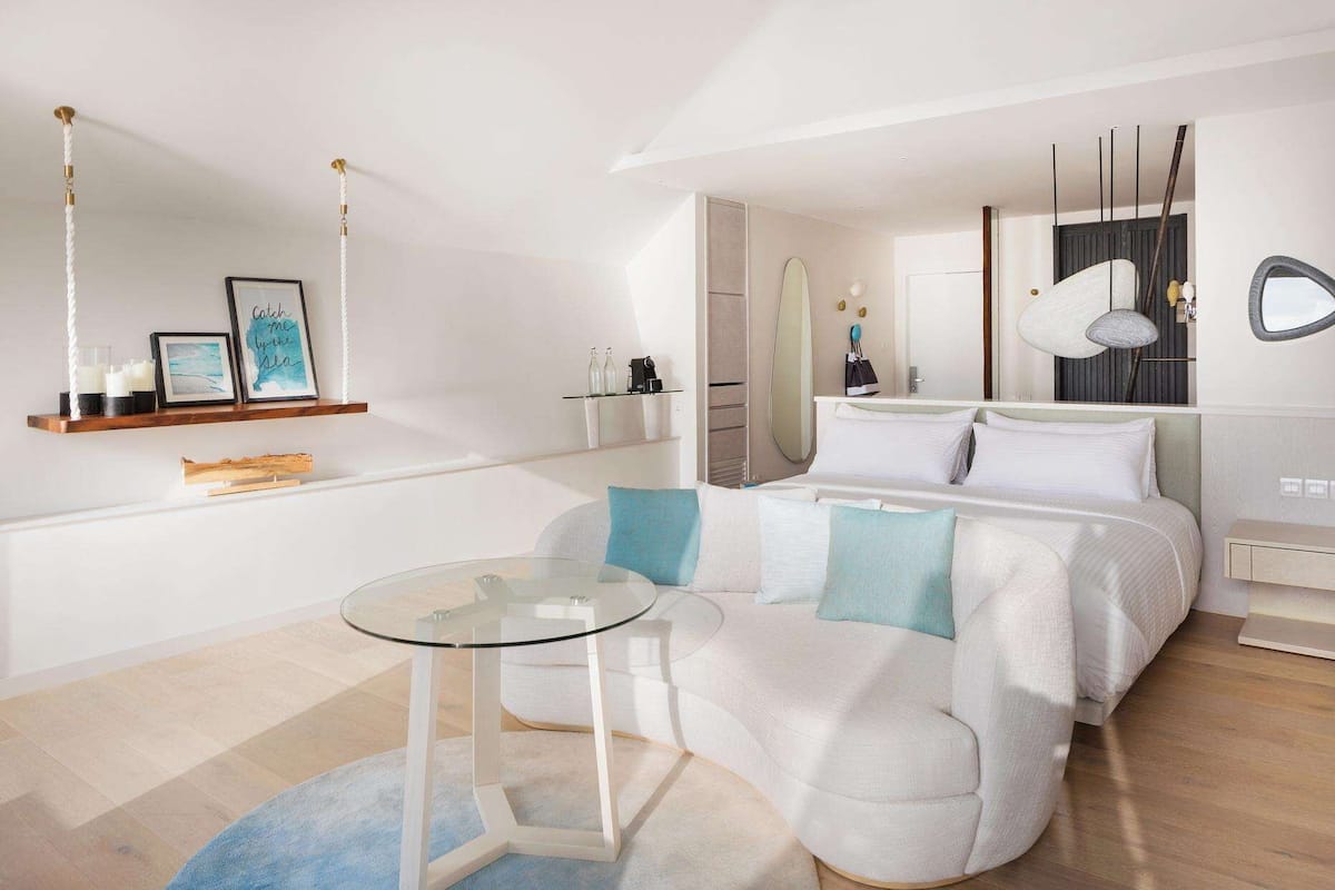 Ein modernes Schlafzimmer mit einem Bett, einem Glastisch und einer Couch.