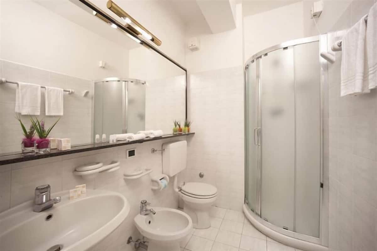 Quarto quádruplo básico | Banheiro | Chuveiro, produtos de toalete grátis, secador de cabelo, bidê