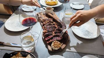 Een eettafel met een steak, wijnglazen en borden.