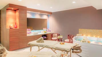 Relax in a serene spa room with a bathtub, vanity, and massage table.