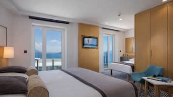 A hotel room with a bed, a desk, a chair, and a TV.
