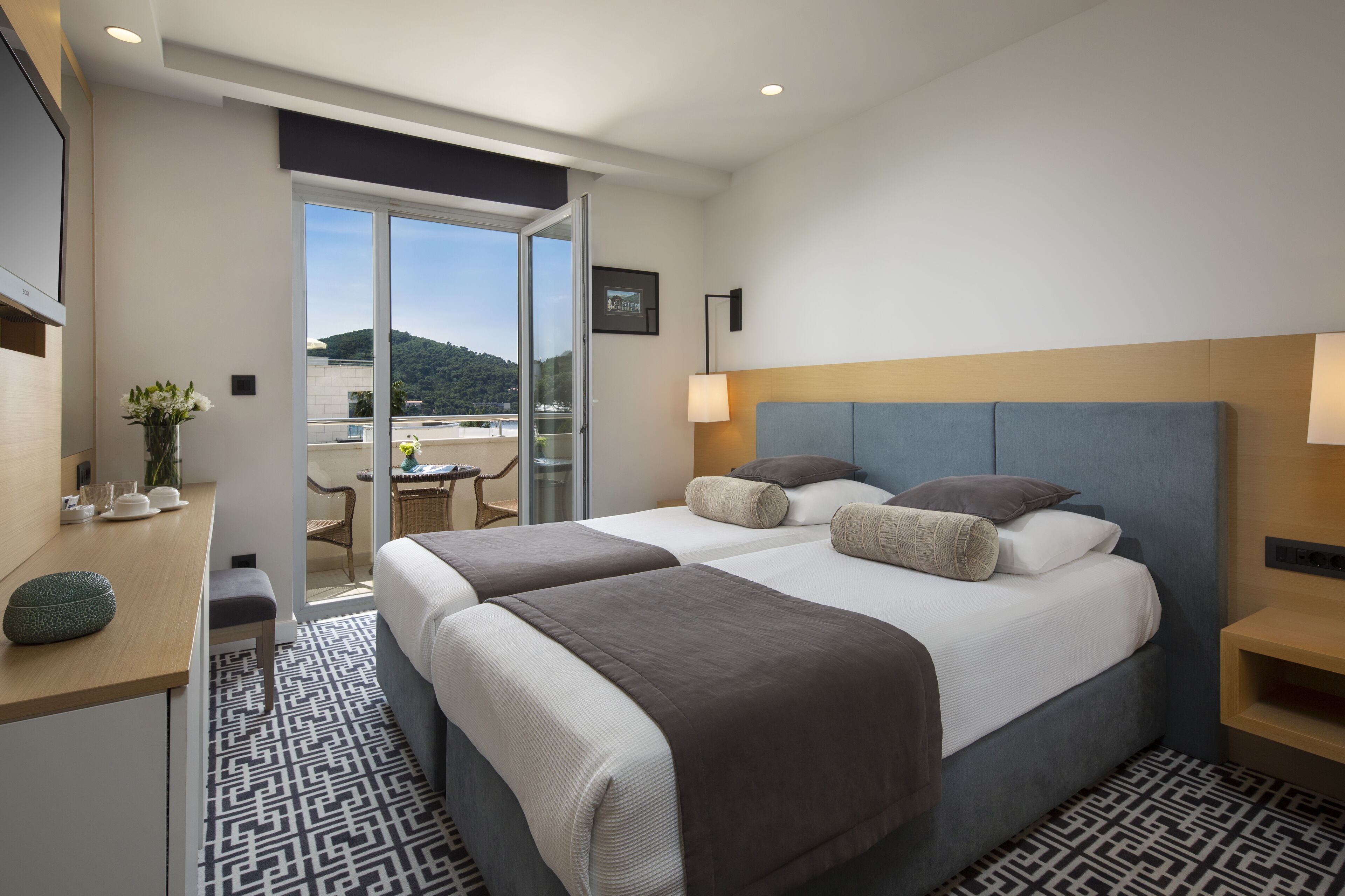Habitación de hotel con dos camas, un escritorio y una silla.