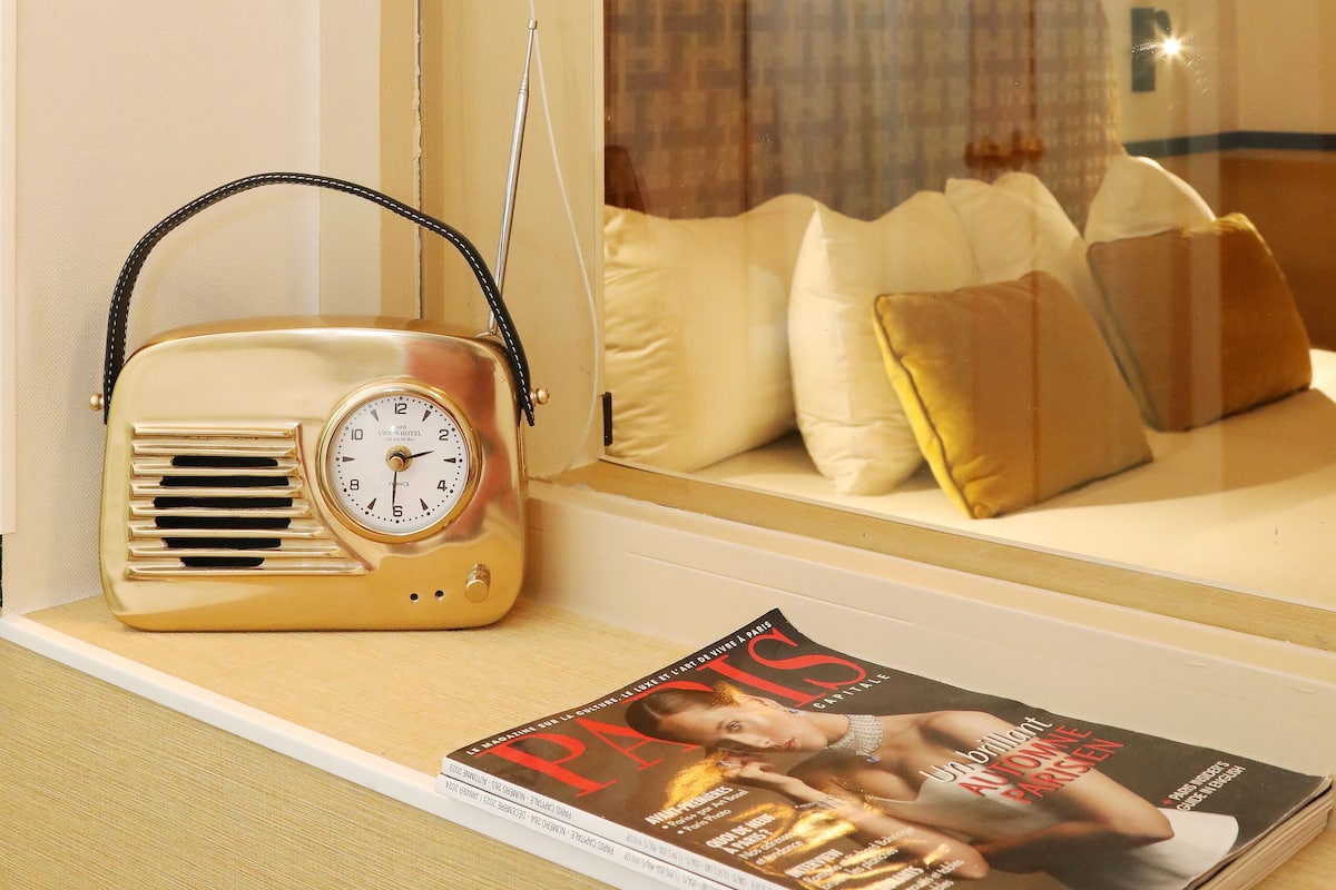 A room with a window, a radio, and a magazine on a table.