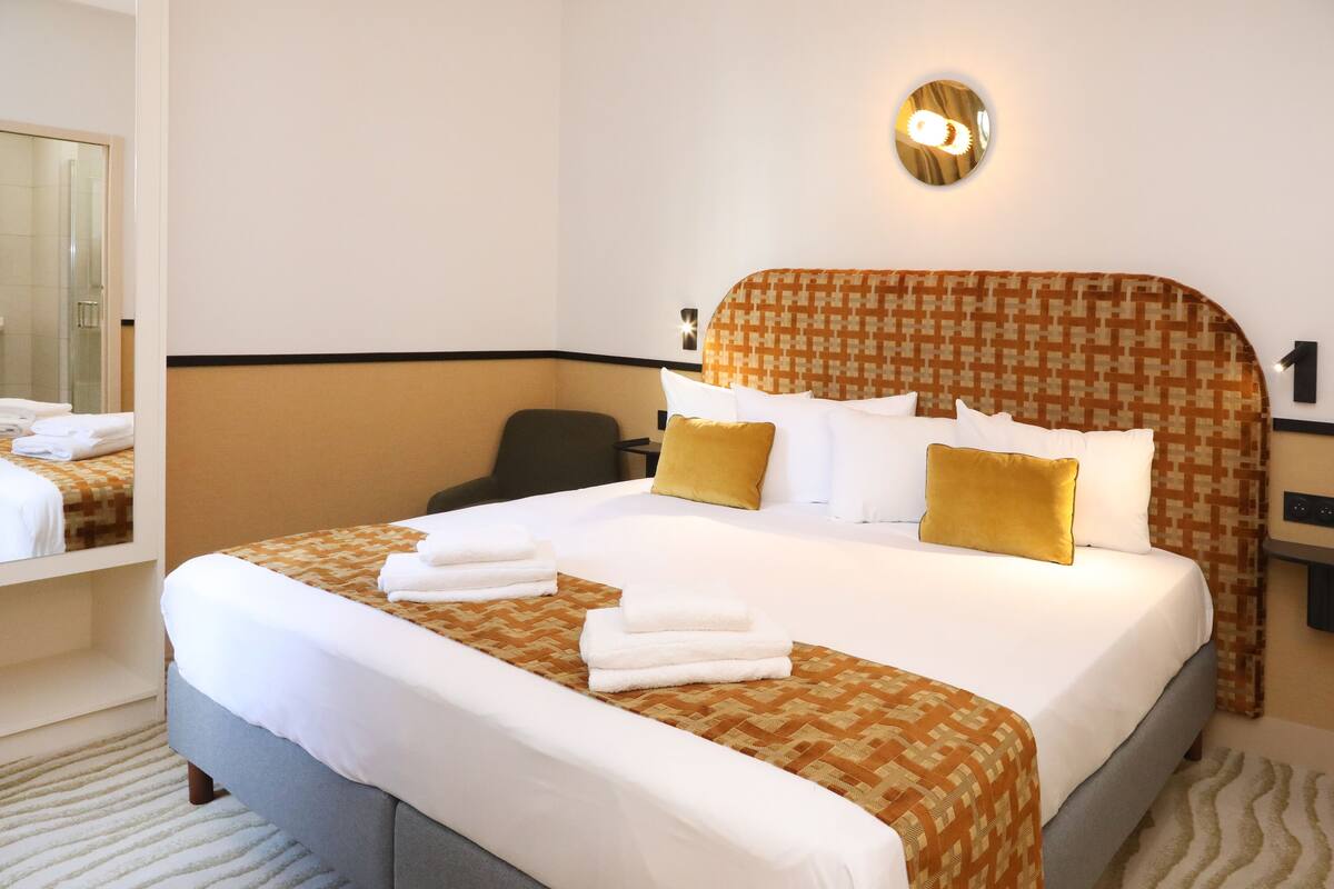 Una habitación de hotel con una cama grande, un escritorio y una silla.