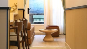 En hotellkorridor med utsikt över en sjö, en sittgrupp med bord och stolar samt en dekorativ gyllene rävstaty.