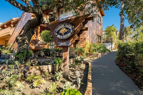 A building with a sign for 'Carmel Oaks Inn & Suites' and a pathway leading to it.. Clarion Collection Carmel Oaks Inn